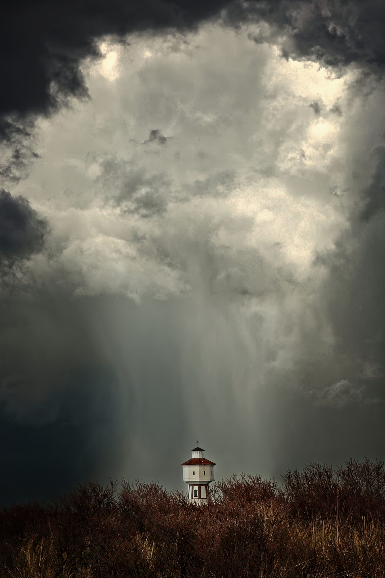 Water tower under heavy clouds
