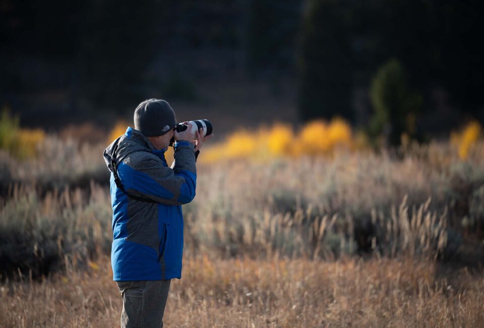 A photographer carefully capturing an image outdoors, representing a practical and trustworthy approach to AI as a supportive tool.