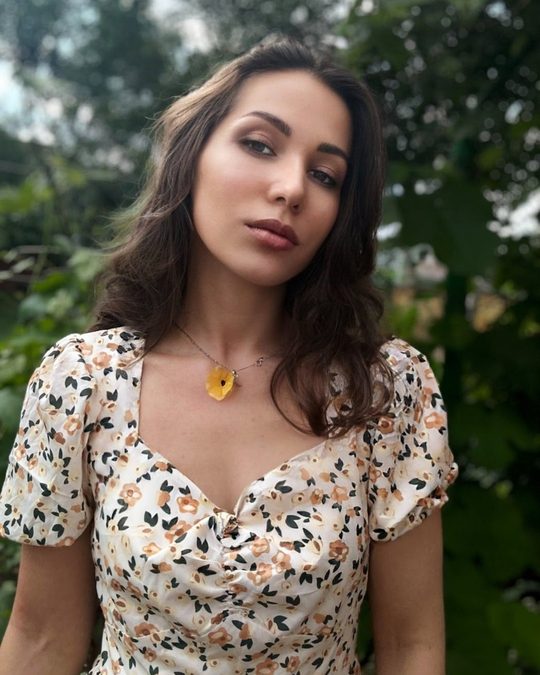 Woman in a floral dress against green foliage, before the Bloom LUT